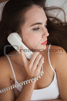 Pretty brunette on the phone in bed