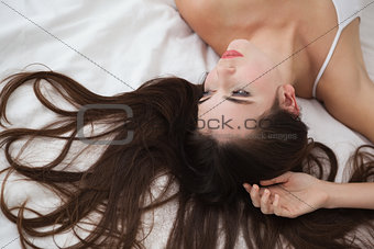 Pretty brunette posing on bed