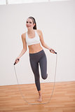 Fit brunette using skipping rope