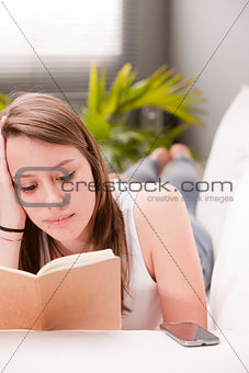lying girl studying on a sofa