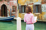 Young woman in venice, italy looking at map. rear view