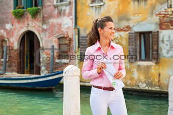 Happy young woman with map in venice, italy