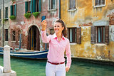 Happy young woman making selfie in venice, italy