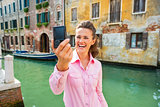 Happy young woman making selfie in venice, italy