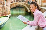 Happy young woman with map in venice, italy