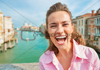 Portrait of happy young woman standing on bridge with grand cana