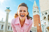 Portrait of happy young woman against campanile di san marco in 