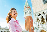 Happy young woman against campanile di san marco in venice, ital
