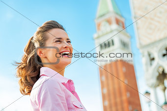 Portrait of happy young woman against campanile di san marco in 