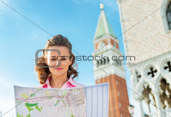 Portrait of young woman looking at map against campanile di san 