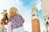 Mother and baby looking on campanile di san marco in venice, ita