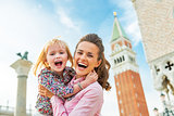 Portrait of happy mother and baby against campanile di san marco