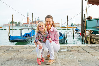 Portrait of smiling mother and baby on grand canal embankment in