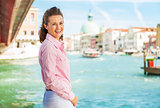 Portrait of happy young woman standing on grand canal embankment