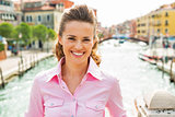 Portrait of smiling young woman standing on bridge in venice, it