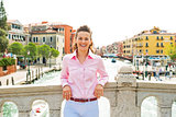 Portrait of smiling young woman standing on bridge in venice, it