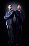 Two young businessmen full body, isolated on black