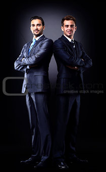 Two young businessmen full body, isolated on black