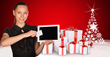 Beautiful businesswoman holding tablet PC. New Year tree and gifts as backdrop