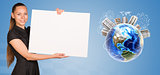 Beautiful businesswoman holding blank paper sheet. Beside is miniature Earth with houses on it