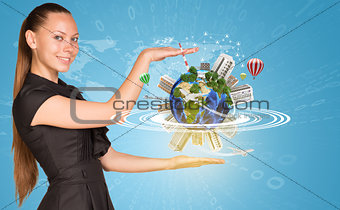 Beautiful businesswoman holding miniature Earth with trees, houses etc. on it