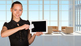 Beautiful businesswoman holding tablet PC. White roomy hall with sofas and coffee table as backdrop