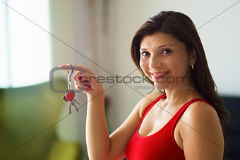 Portrait woman home owner smiling holding keys new house