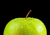 half fresh green apple with droplets of water against black background