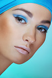 Close-up  portrait of attractive woman in turquoise scarf on the head with bright blue makeup