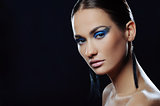 Close-up portrait of beautiful girl with blue festive make-up in long earrings