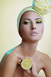 beautiful woman with festive makeup in yellow scarf on the head with lemon in hand