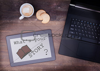 Tablet touch computer gadget on wooden table, what's your story