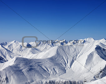 Winter mountains and chair-lift at nice day
