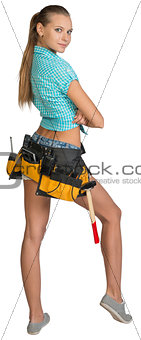 Pretty girl in shorts, shirt and tool belt with tools. Full length rear view