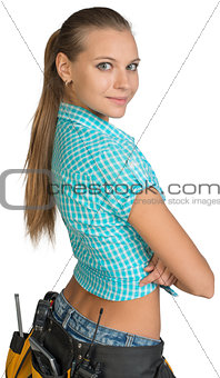 Pretty girl in shorts, shirt and tool belt with tools. Rear view