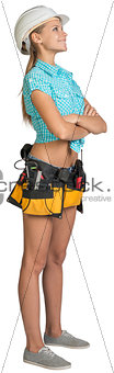 Looking up pretty girl in helmet, shorts, shirt and tool belt with tools. Full length