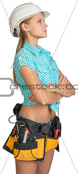 Looking up pretty girl in helmet, shorts, shirt and tool belt with tools