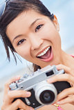 Asian Woman at Beach Taking Photograph With Camera