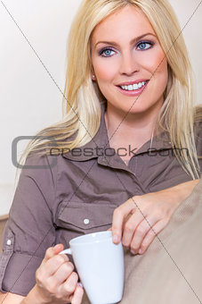 Beautiful Blond Woman Drinking Tea or Coffee At Home