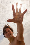 Man Reaching for Sun Flare on Beach 