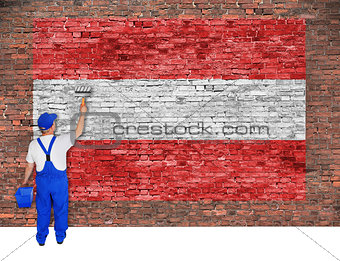 House painter covers brick wall with flag of Austria