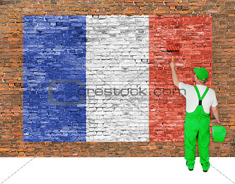 House painter covers brick wall with flag of France