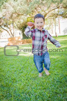 Cute Young Mixed Race Boy Playing Football Outside