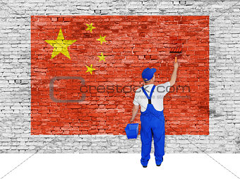 House painter covers brick wall with flag of China
