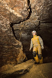 Young female caver exploring the cave 