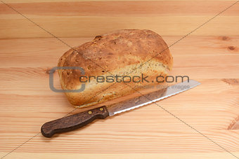 Fresh loaf of oat and linseed bread with a bread knife