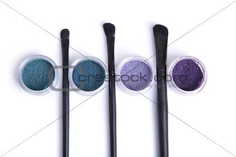 Top view of mineral eye shadows in pastel colors and brushes