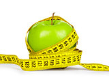 Diet concept. Green apple and yellow measuring tape on an isolat