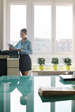 Young woman copying document with photocopy in office