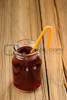 Cherry juice in jar with cocktail tube and vanilla vertical